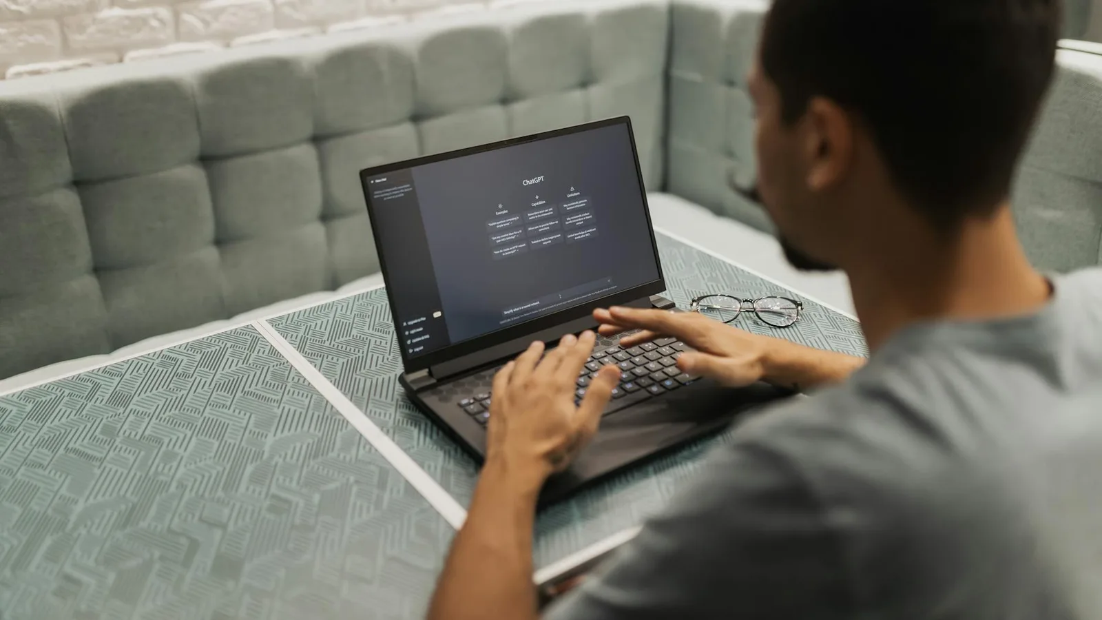 A man working on a laptop in a cozy, modern office space with a focus on technology.