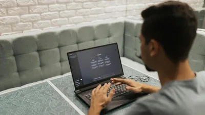 A man working on a laptop in a cozy, modern office space with a focus on technology.