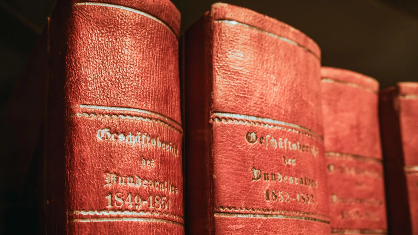 Red leather-bound parliamentary books from 19th century in Bern library, Switzerland.